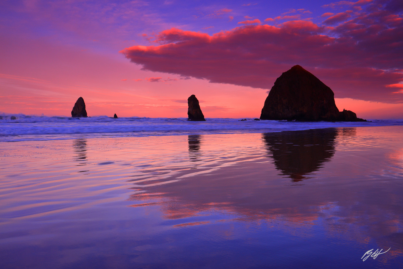 Sunrise and cloud Reflections with Haystack Rock and the Needles from Cannon Beach on the Oregon Coast