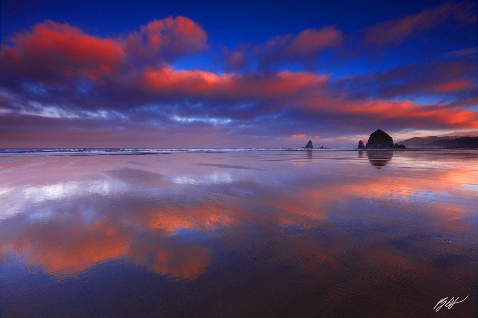 Sunrise with Floating Cloud Reflections and Haystack Rock on Cannon Beach in Oregon
