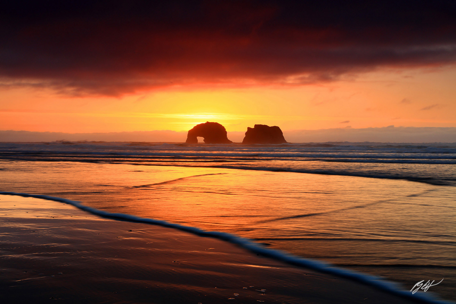 Sunset Glow through the Arch of Northern Twin Rock from Rockaway Beach in Rockaway Oregon