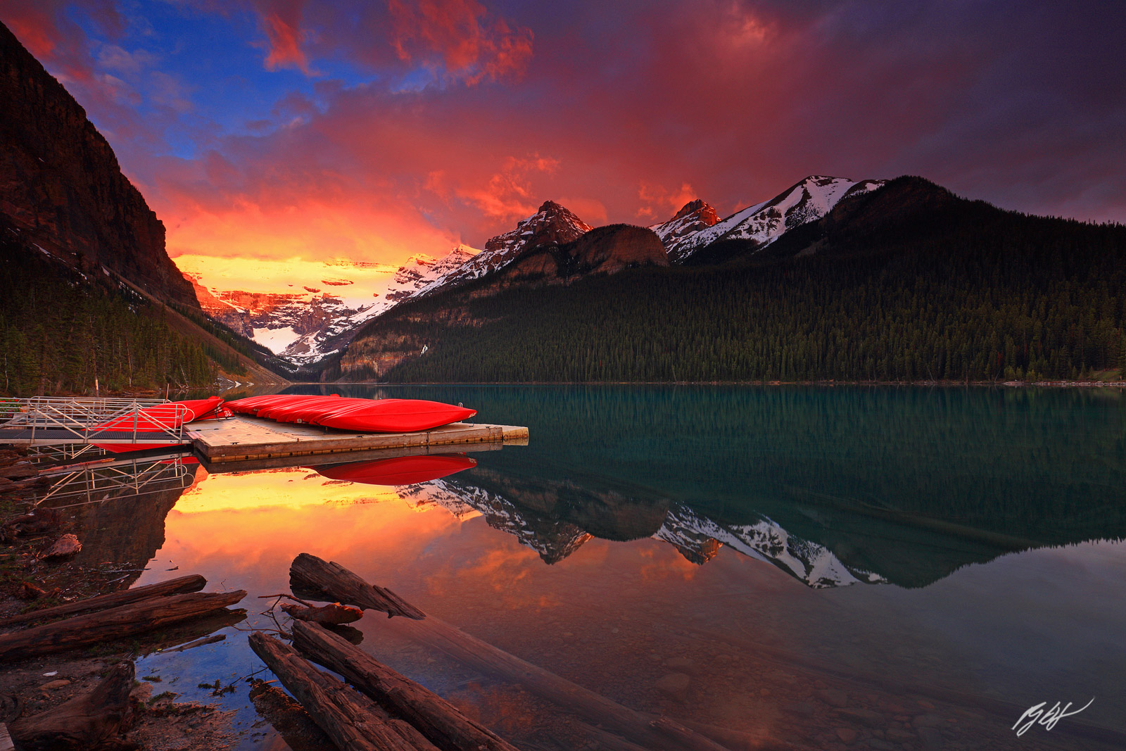 Sunrise and Canoes Reflected in Lake Louise in Banff National Park in Alberta, Canada